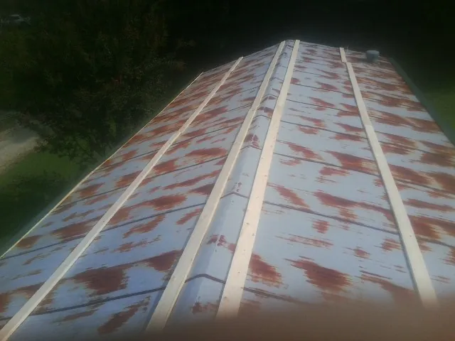 Rusted metal roof panels with new wood purlins before replacement — Storm Damage Roof Repair in Sandown by Roofing Brothers