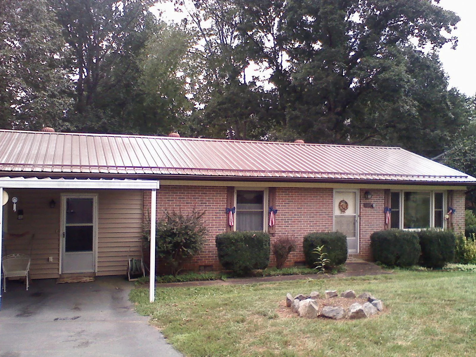 Bronze metal roof and carport on a brick ranch home — Roof Repair work by our crew in Sandown